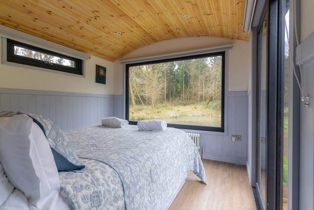 Lodge bedroom with picture window over the pond